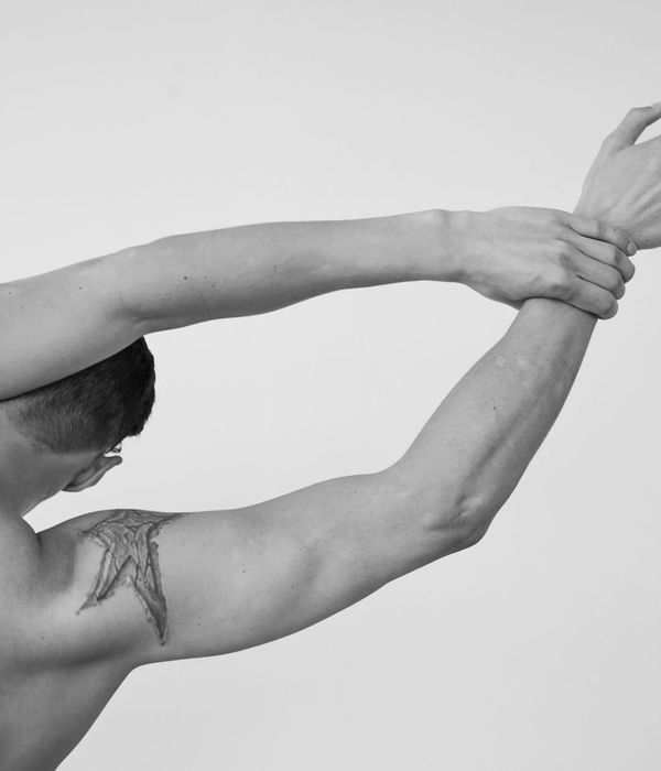 Man performing a controlled strength exercise in a modern, minimalist gym.